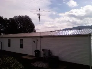 New metal roof on a single wide mobile home with a TV antenna in Colchester